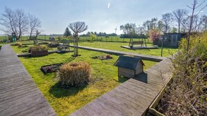 A park with pathways, benches, and a small building. - Vacation apartment Treibholz | Quiet North Sea vacation Hilgenriedersiel (Hagermarsch)