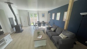 Ein Wohnzimmer mit einer Couch, einem Couchtisch, einem Kamin und einem Essbereich mit Stühlen und einem Tisch.