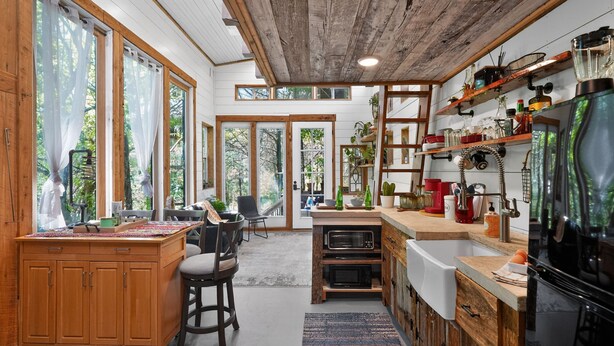 A spacious kitchen with wooden cabinetry, a large island, and a view of the outdoors. - Simply Nature in the City (Smyrna)