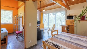 Una habitación con cama, escritorio, silla, mesa y ventana.