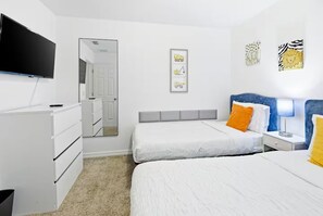 A hotel room with two beds, a TV, a dresser, and a mirror. - Orlando Family Retreat Near Disney Magic (Davenport)