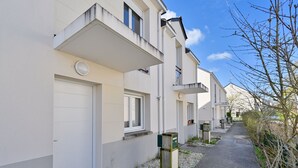 A row of modern, single-story buildings with flat roofs, white exterior walls, and a narrow pathway between them. - Le Refuge Balnéaire - À 3km de la plage (Pornichet)