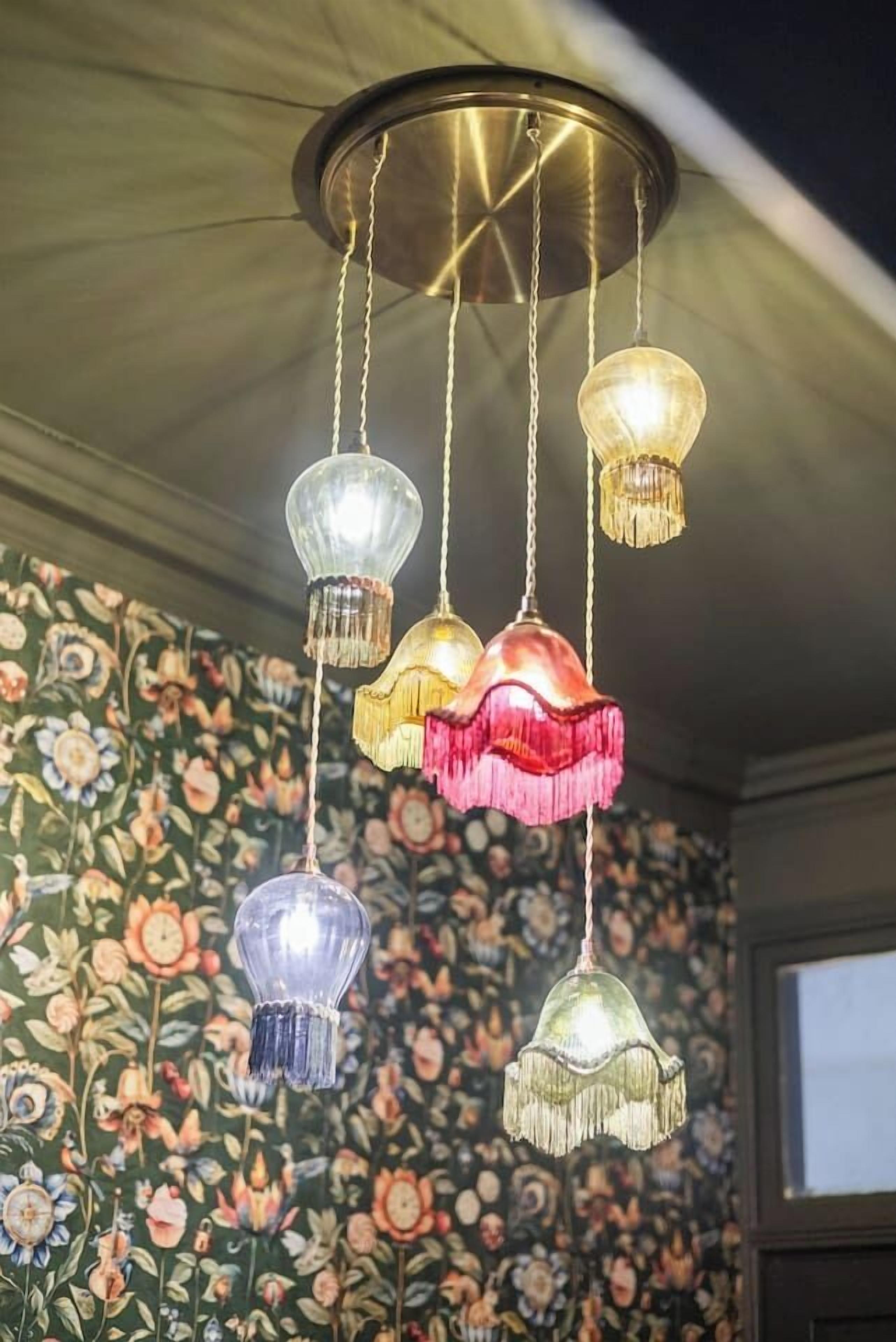 Un plafond agrémenté d’un luminaire décoratif composé de plusieurs lampes suspendues.