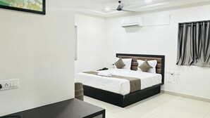 Une chambre d’hôtel moderne, équipée d’un lit, d’un bureau et ornée d’un tableau au mur.
