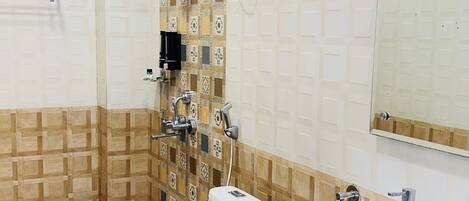 A bathroom with a toilet, bidet, shower, and sink.