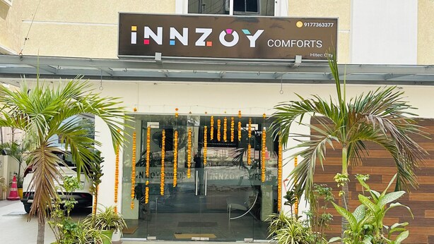 Un bâtiment sur lequel est apposée une enseigne indiquant « INNZOY COMFORTS » et sur lequel figure un numéro de téléphone.