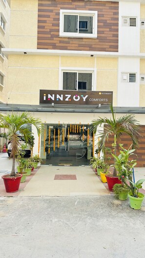 A building with a sign reading 'INNZOY COMFORTS' and a contact number. - Innzoy Comforts (Hyderabad)