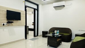 Un salon moderne doté d’un téléviseur à écran plat, d’un ventilateur de plafond et d’une grande fenêtre.