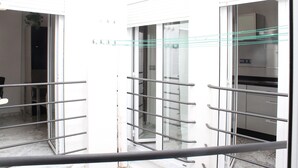 Een modern interieur met glazen deuren, metalen handgrepen en een marmeren vloer.