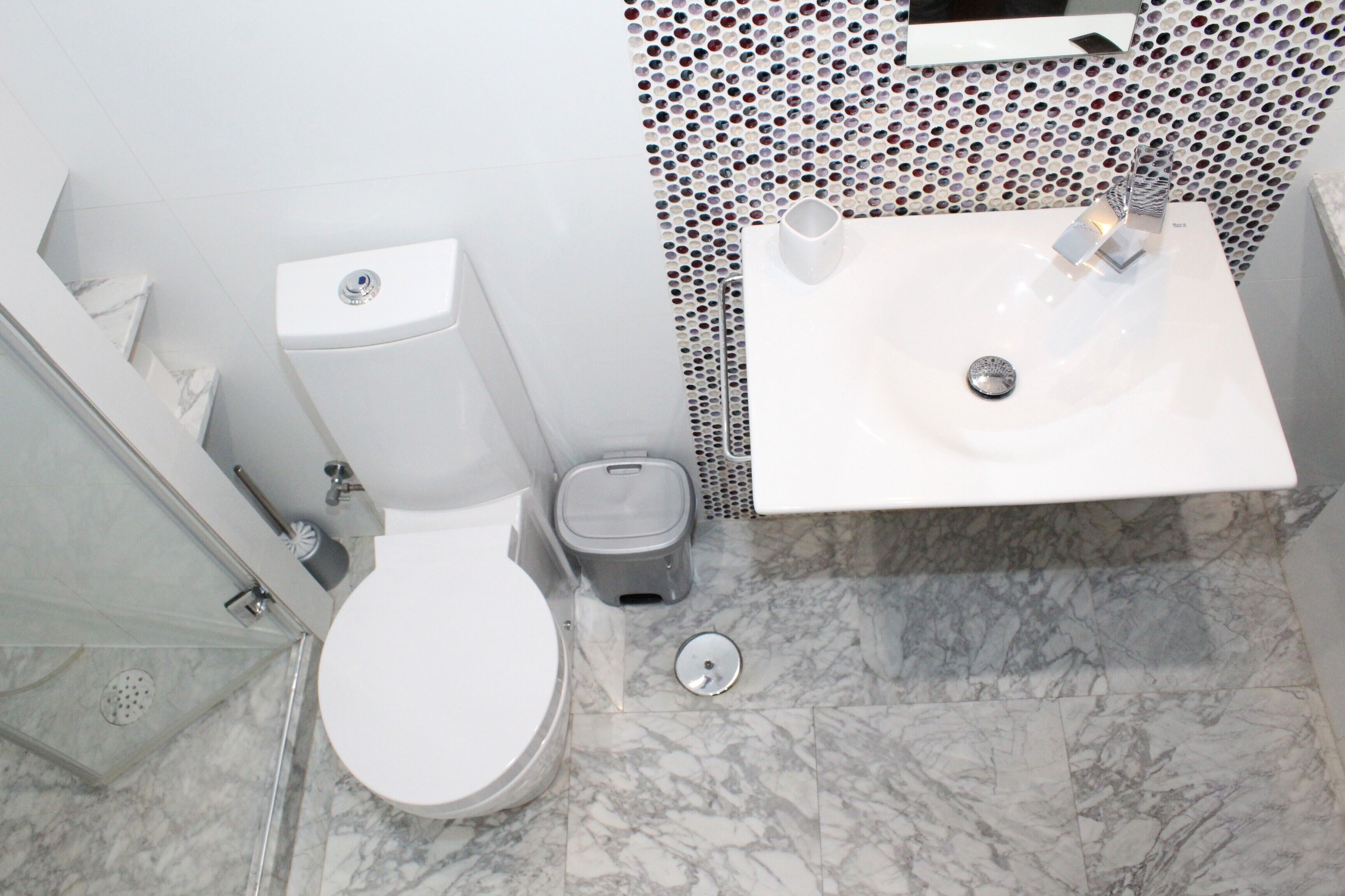 A bathroom with a toilet, sink, and shower.