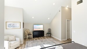 A bedroom with a bed, a TV, a dresser, a chair, and a couch. - Storybook Stone Home | On the Bourbon Trail (Lawrenceburg)