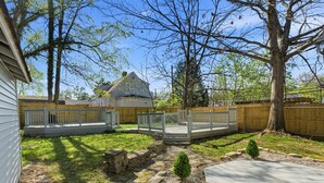 A backyard with a wooden deck, stone pathway, and a small tree. - Storybook Stone Home | On the Bourbon Trail (Lawrenceburg)