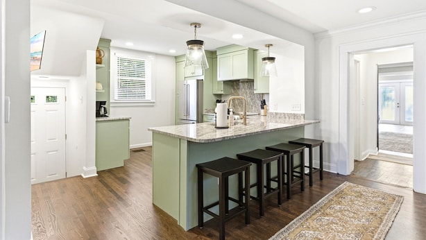 A modern kitchen with a central island, bar stools, and pendant lighting. - Storybook Stone Home | On the Bourbon Trail (Lawrenceburg)