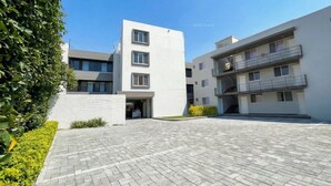 Um hotel moderno com um pátio pavimentado, vários andares e varandas.