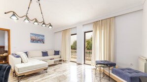 Uma sala de estar moderna com um sofá, um banquinho e uma mesinha.