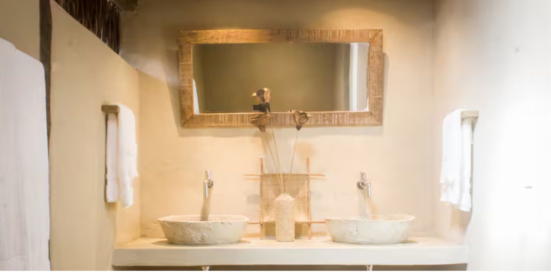 Une salle de bain avec deux lavabos, un miroir et des serviettes.