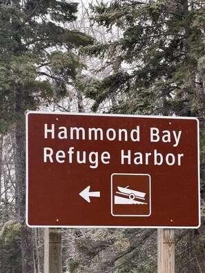 Un panneau de signalisation indiquant la direction du port de refuge de Hammond Bay, avec une flèche pointant vers la gauche.