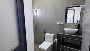 A bathroom with a toilet, bidet, and sink.