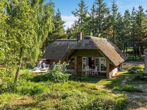 A thatched-roof cottage with outdoor seating, surrounded by trees and greenery. - "Ullamaj" - 700m from the sea by Interhome (Rømø)