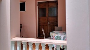 A room with a wooden door, a small window, and a balcony with a white railing. - La Sagesse Bay View (St. David)