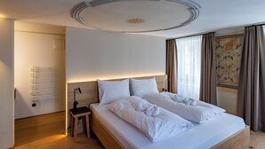 Ein Hotelzimmer mit Bett, Nachttisch, Lampe und Heizkörper.