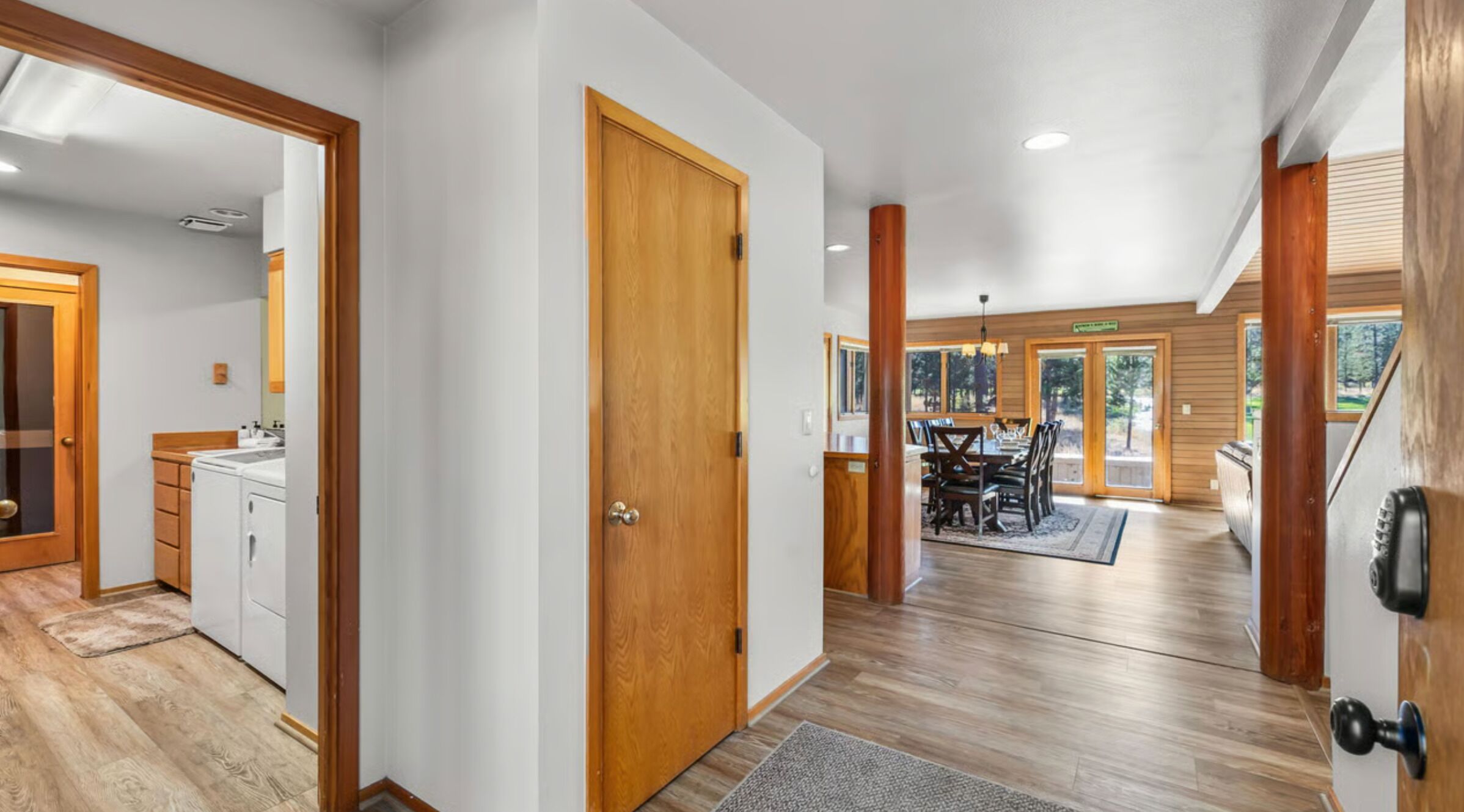 Entryway with wood-look flooring leading to the laundry room and dining area.