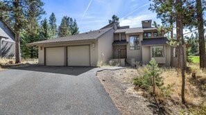 Exterior of the multi-level home with a two-car garage and paved driveway. - 5 Bedrooms - 12 SHARC Passes- Hot Tub - Bikes- Dog (Sunriver)