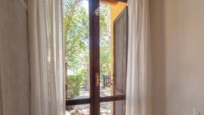 Une porte donnant sur un jardin, une porte en bois et un sol carrelé.