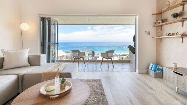 Ein modernes Wohnzimmer mit einer Couch, einem Couchtisch und Blick auf den Ozean.