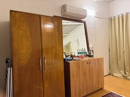 Un armario de madera con espejo, un dispensador de agua y una tetera encima.
