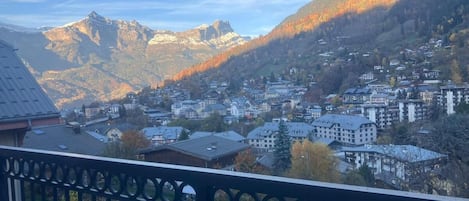 Uma cidade montanhosa com edifícios e um pico de montanha imponente ao fundo.