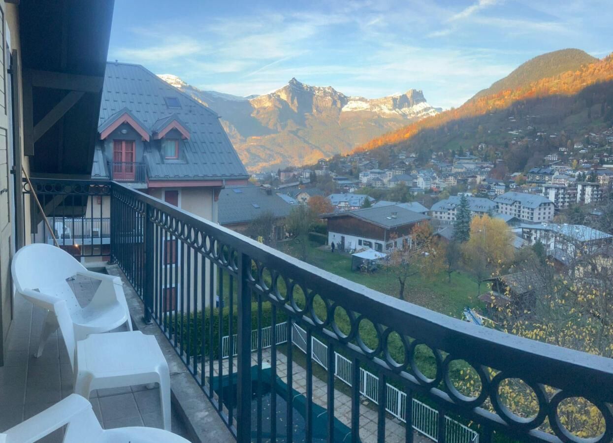 A balcony with a view of a town and mountains.