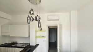 A modern kitchen with white cabinets, a black countertop, and a hanging light fixture. - Diletta's Residence - Two-room apartment 2 (Sant'Isidoro)