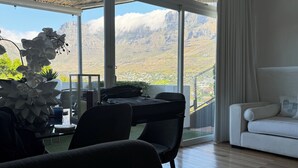 Une chambre d’hôtel moderne dotée d’une grande fenêtre, d’un coin repas et d’un canapé.