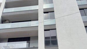 Monikerroksinen rakennus, jossa on moderni arkkitehtoninen ilme, suuret ikkunat ja parvekkeet.