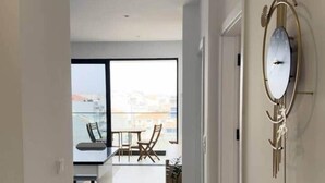 Un interior moderno con vista al mar, un comedor y un reloj de pared original.