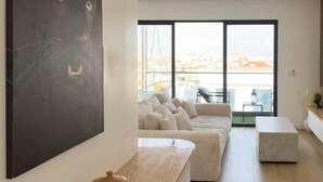 Ein modernes Wohnzimmer mit großem Fenster, einer Couch und einem Couchtisch.