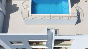 A rooftop pool with a clear blue water surface, surrounded by a white pool deck and a metal safety railing. - 2 bdr aprt, stunning view,  rooftop pool - LCGR (Praia)