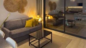 A modern living room with a sofa, coffee table, and a glass partition. - 2 bdr aprt, stunning view,  rooftop pool - LCGR (Praia)