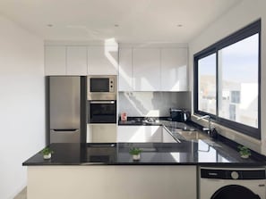Une cuisine moderne équipée d’un lave-vaisselle, d’une cuisinière et d’un évier.