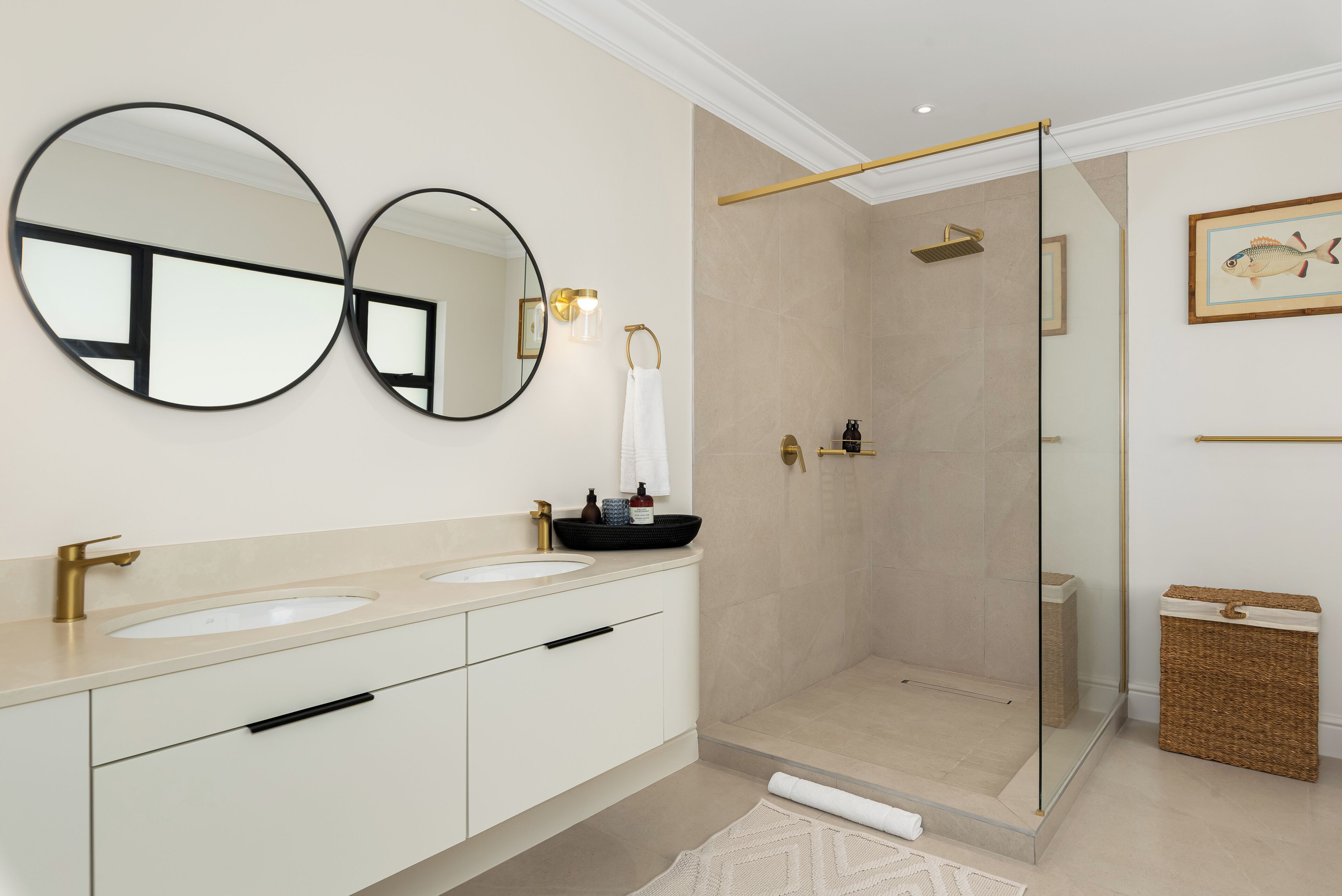 A modern bathroom with two sinks, a glass-enclosed shower, and a large mirror.