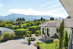 Un jardin agrémenté d’une fontaine, d’un belvédère et offrant une vue sur les montagnes.