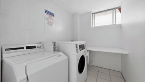 Een wasruimte met een Maytag wasmachine en droger, een raam en een bord aan de muur.