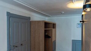 A hallway with wooden flooring, a grey door, and a wooden wardrobe. - Münsterhus Josefs Alpine Lodge - Three Towers Triple Room (Schruns)