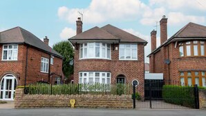 A two-story brick house with a front garden, a driveway, and a black gate. - Beautiful Escape | Wi-Fi | Garden & Free Parking - Pass the Keys (Nottingham)