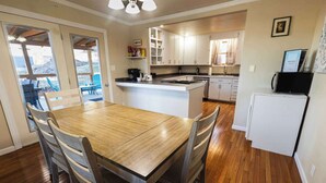 A kitchen with a central island, wooden dining table, and chairs. - The Golden Getaway in Lead (Lead)