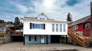 A two-story house with a garage, a covered porch, and a wooden staircase leading to the upper floor. - The Golden Getaway in Lead (Lead)