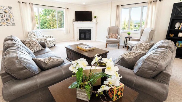 A living room with leather sofas, a fireplace, a television, and a view of greenery outside. - The Golden Getaway in Lead (Lead)