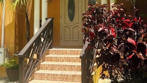 A building entrance with a tiled staircase, a double door, and a small porch area. - Cazuria - by Zenbreak (Newbury)