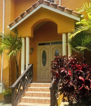 A building entrance with a tiled staircase, a double door, and a small porch area. - Cazuria - by Zenbreak (Newbury)